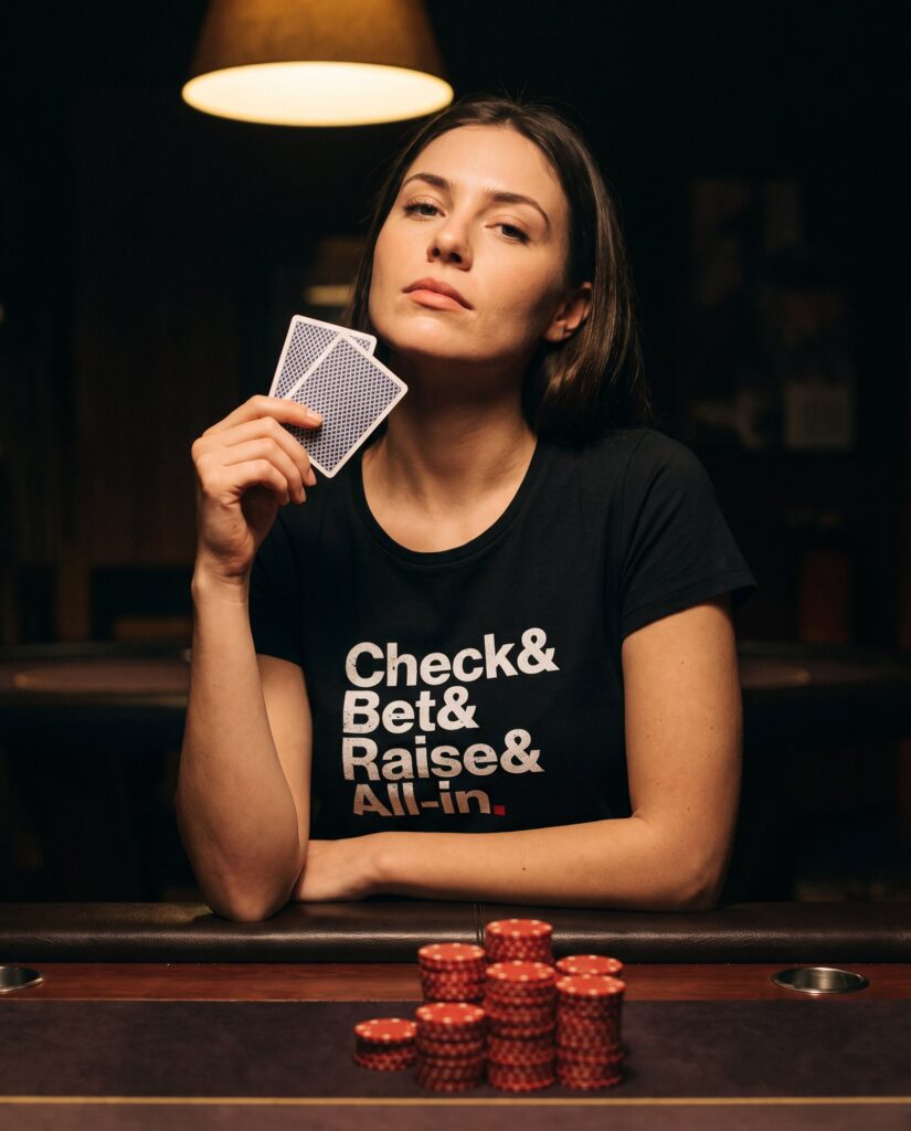Femme en t-shirt Check & Bet & Raise & All-in tenant deux cartes à une table de poker